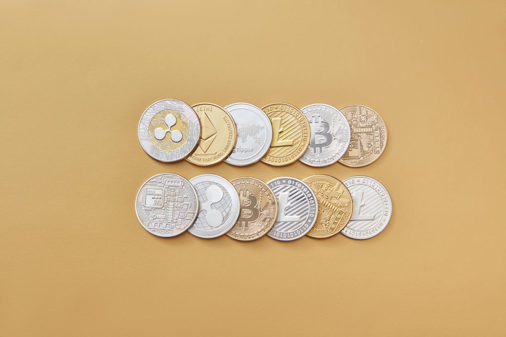 Die besten Kryptowährungen für 2026: Die besten Coins zum Investieren A collection of digital cryptocurrency coins, including Bitcoin and Ethereum, arranged on a stylish gold backdrop.