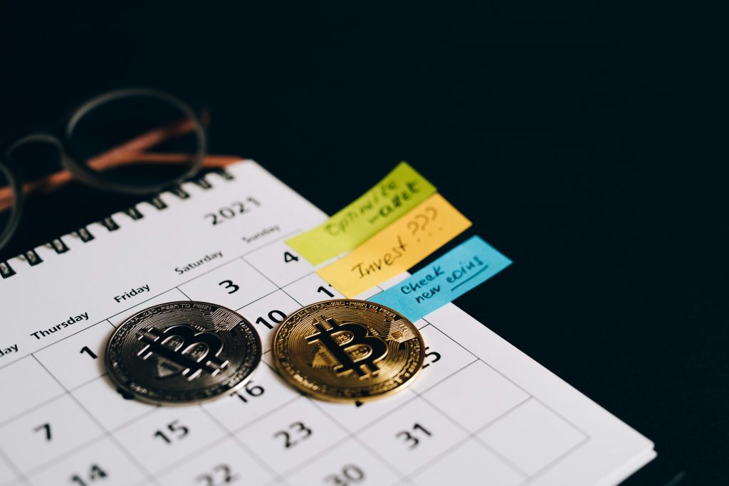 Bitcoin-Mining rentabel? Kosten, Gewinne & Realität 2026 Bitcoin coins placed on a calendar with sticky notes for investment planning.